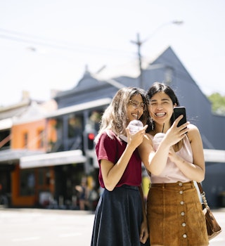 Two slightly dorky hipsters enjoying a day walk in the sunny Surry Hills, Sydney, Australia. The girls are happy to spend some time together eating ice cream and drinking cold drinks.