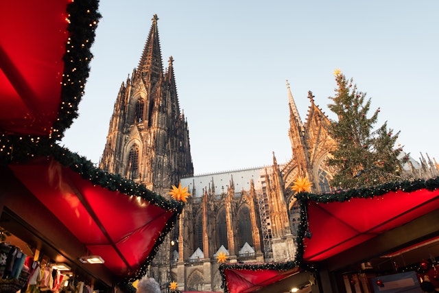 The traditional Christmas market set up in Cologne, Germany, with the cathedral in the background.