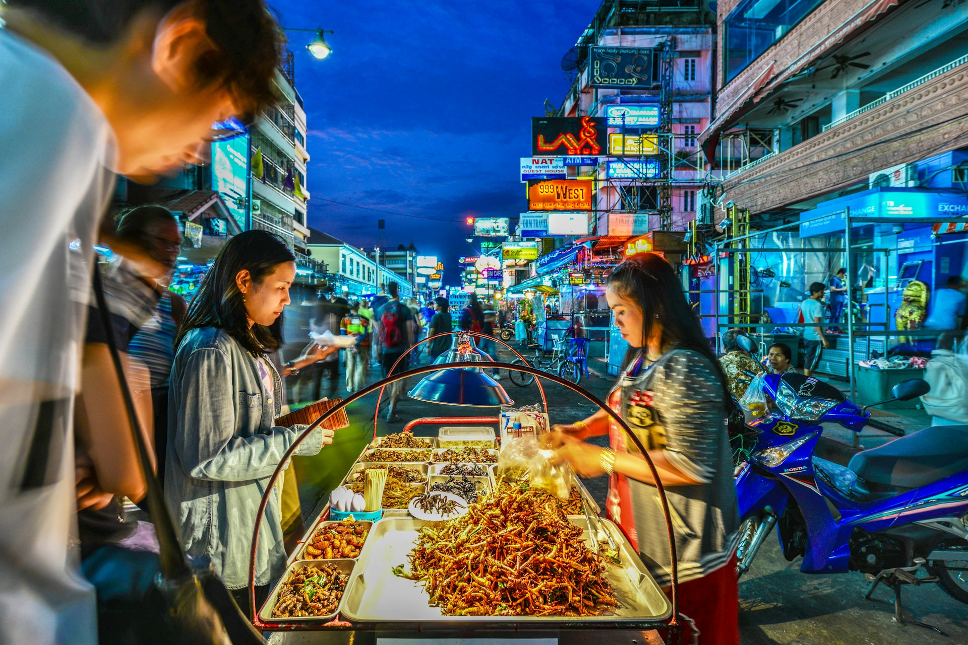 A street vendor sells fried cockroaches and other insects to tourists on Khao San Road in Bangkok, Thailand