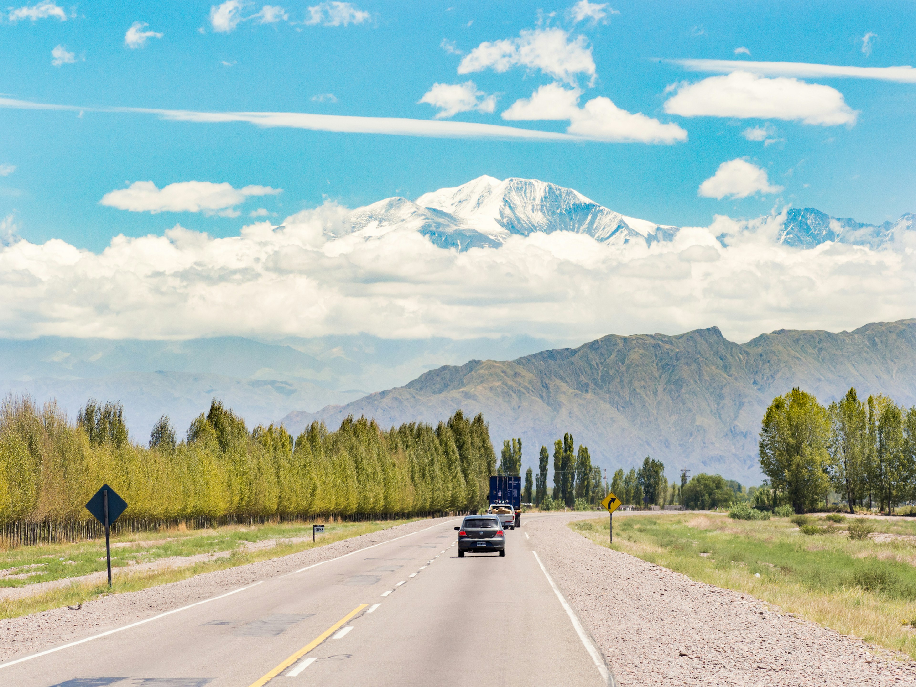 Mendoza, Argentina - February 13, 2013: Vehicles driving through the road and the view of the landscape near Mendoza, Argentina.