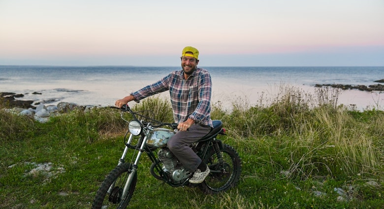 Dean Petty rides his motorcycle along the coast of Nova Scotia © Jack Pearce/Lonely Planet