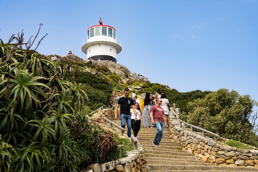 People walking down the stairs in front of the lighthouse at Cape Point, South Africa