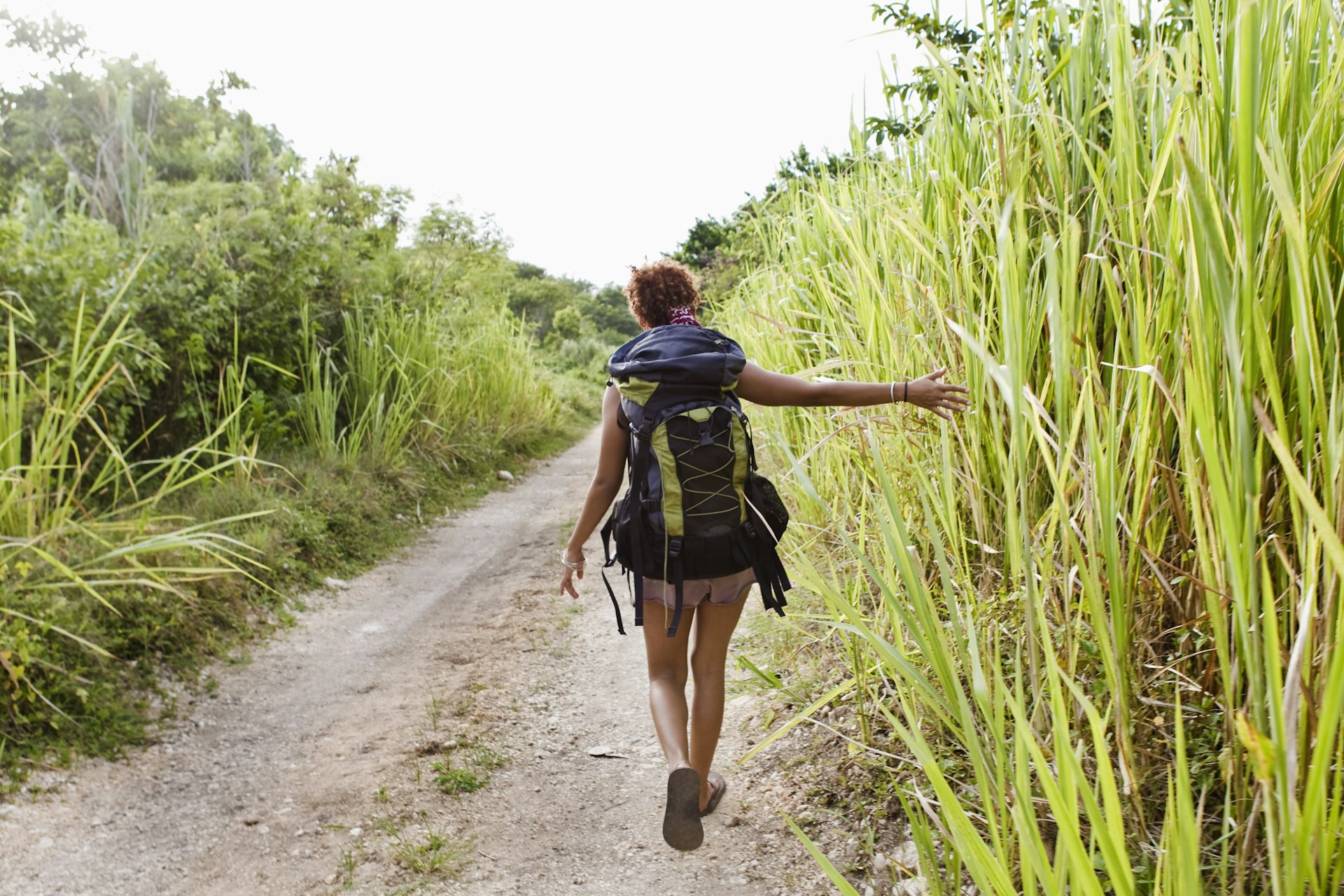 A backpacker walking along a dirt road in Jamaica