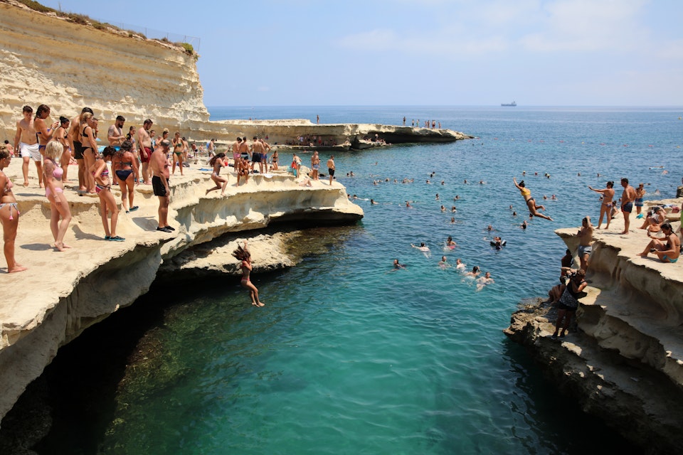 Marsaxlokk, Malta – August 13, 2019: St. Peter's Pool near Marsaxlokk. A very popular place for Locals and Tourists. Malta
