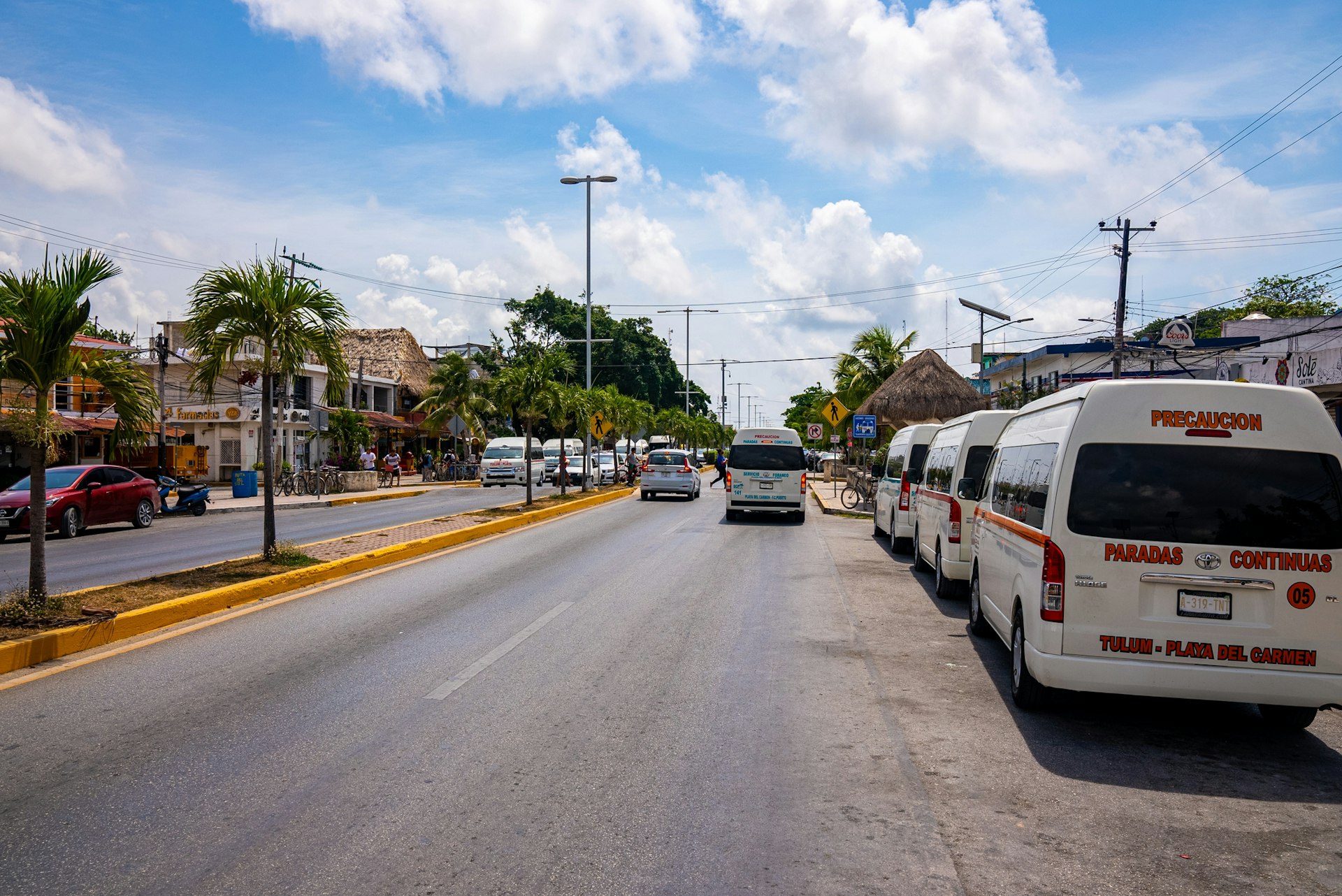 A road with shared taxi vans (colectivos) lined up awaiting passengers