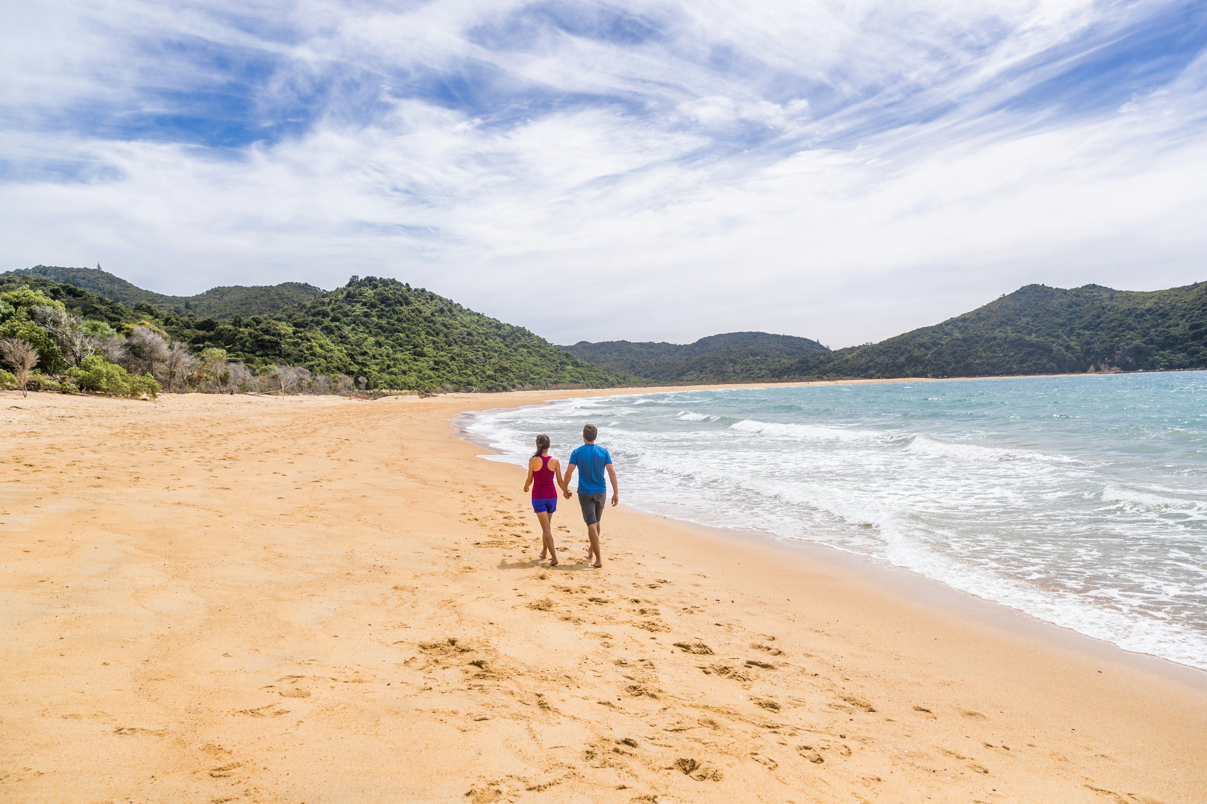 Abel Tasman National Park beach tourists hikers tramping on coast track trail, famous travel destinatinon. Wilderness reserve at the north end of New Zealand's South Island