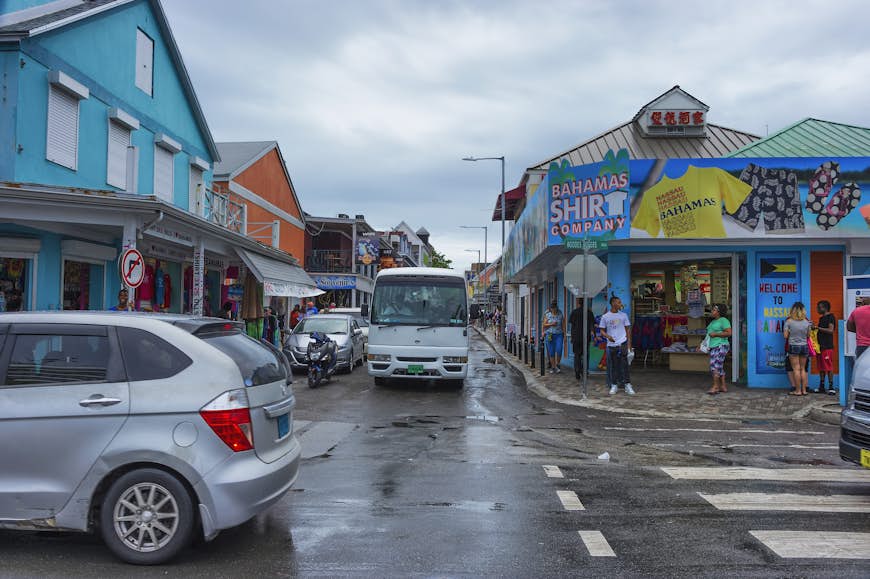 Tourist flock the streets along Nassau's harbor to eat and shop amidst car and bus traffic. Straw vending is Bahama's oldest industries. 