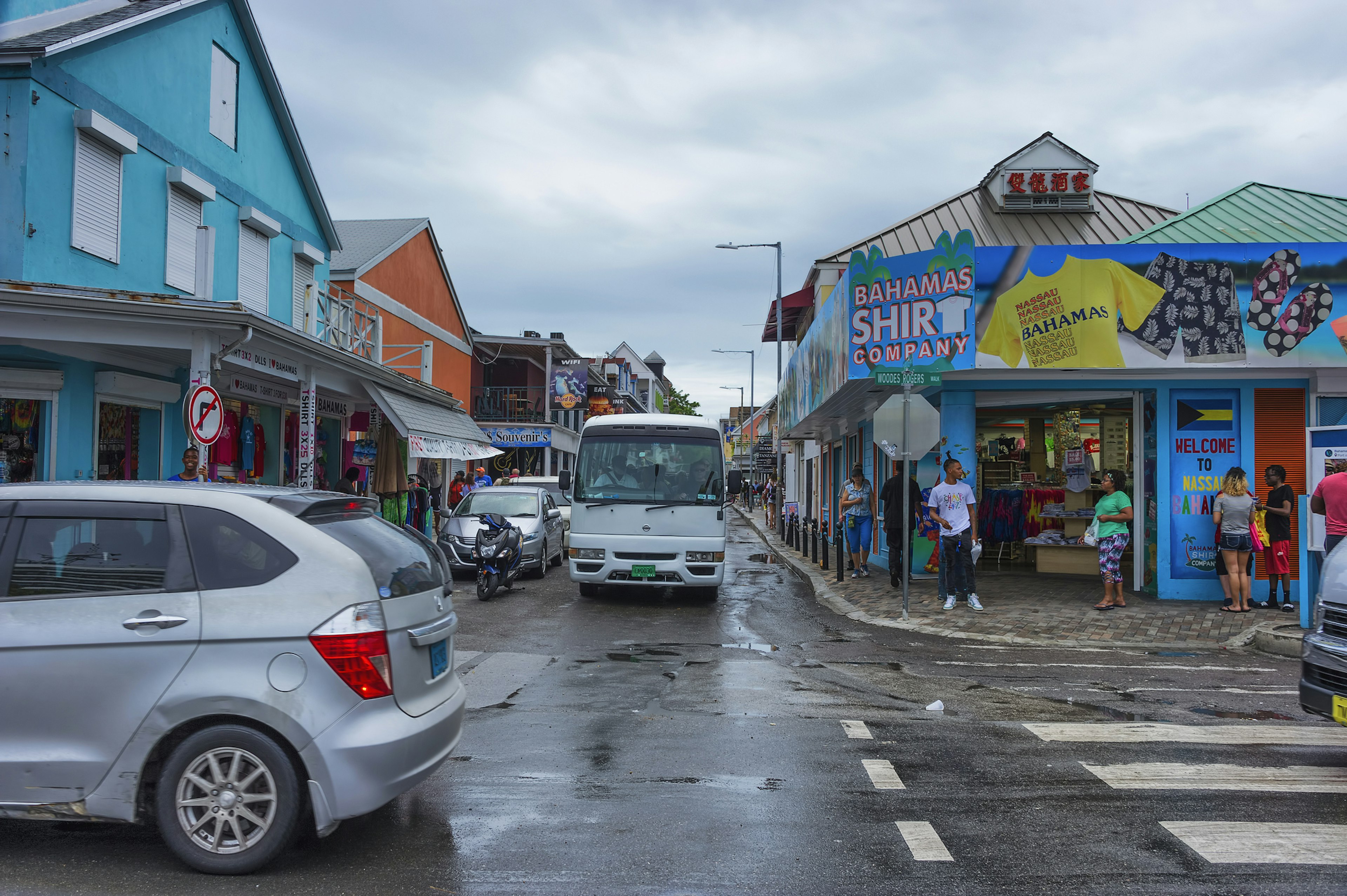 Tourist flock the streets along Nassau's harbor to eat and shop amidst car and bus traffic. Straw vending is Bahama's oldest industries.