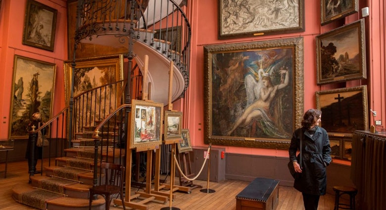 Visiteur, escalier en colimaçon et diverses oeuvres dont celle 'Leda' celle de face conservée au 2ème étage dans la maison-atelier de Gustave Moreau (1826 - 1898) légué par l'artiste à l?État français en 1897, devenu musée national, 2 juin 2016, Paris, France. (Photo by Raphaël GAILLARDE/Gamma-Rapho via Getty Images)