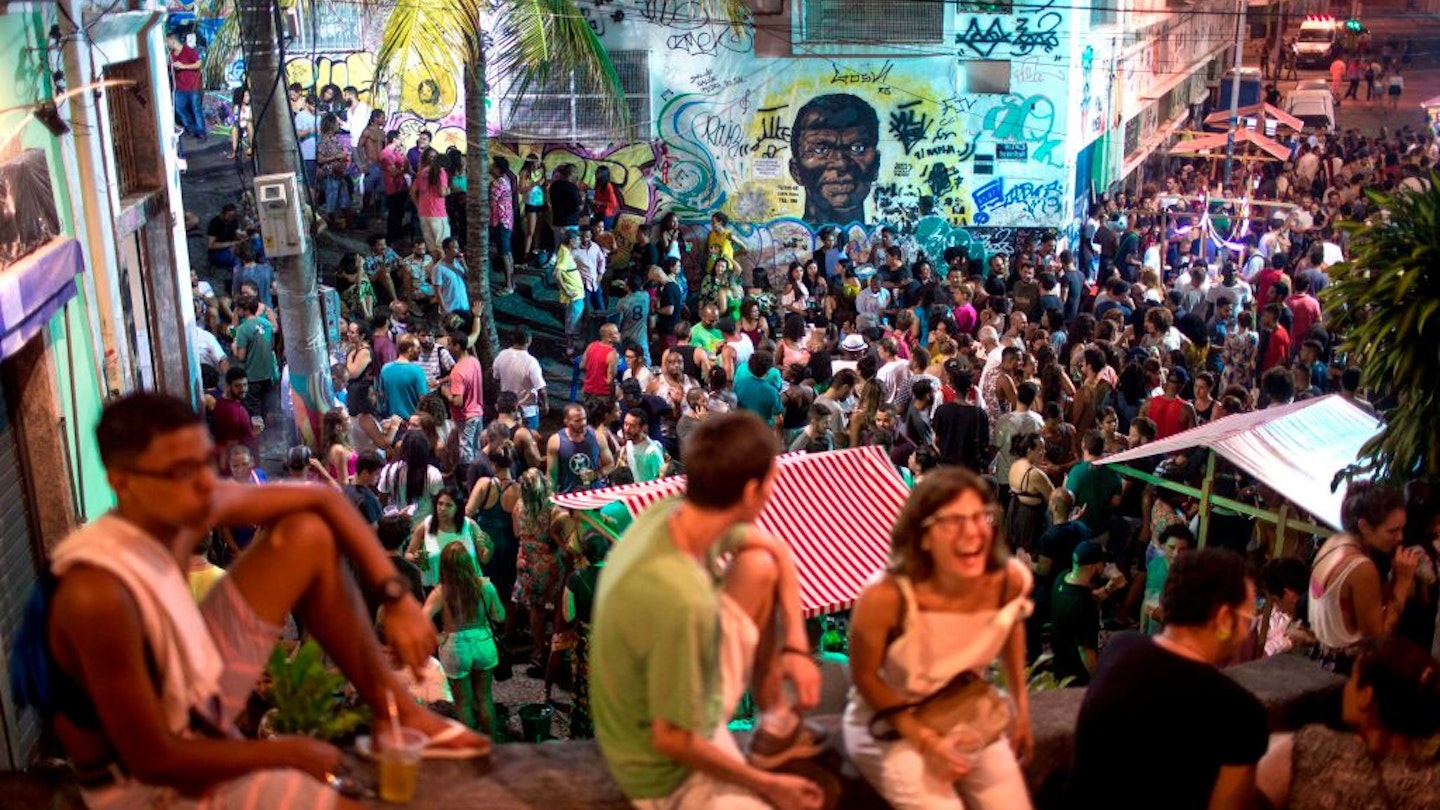 People attend a samba concert in the area of Quilombo Pedra do Sal, backdropped by a graffiti depicting Zumbi Dos Palmares - the main leader of Quilombo dos Palmares in Alagoas state during the colonial period and who became a symbol of the fight against slavery in the country- in downtown Rio de Janeiro, Brazil on December 18, 2017. .In Rio de Janeiro, three communities of descendants of slaves who broke chains from their masters cultivate the memory of their ancestral struggle. Unlike other "quilombos", they are amid the city and their current fight is against real estate speculation. / AFP PHOTO / MAURO PIMENTEL        (Photo credit should read MAURO PIMENTEL/AFP via Getty Images)
899383338
TOPSHOTS, Horizontal, CROWD, SAMBA, CONCERT, EFFIGY, SLAVERY
People attend a samba concert in the area of Quilombo Pedra do Sal, backdropped by a graffiti depicting Zumbi Dos Palmares - the main leader of Quilombo dos Palmares in Alagoas state during the colonial period and who became a symbol of the fight against slavery in the country- in downtown Rio de Janeiro, Brazil on December 18, 2017. In Rio de Janeiro, three communities of descendants of slaves who broke chains from their masters cultivate the memory of their ancestral struggle. Unlike other "quilombos", they are amid the city and their current fight is against real estate speculation. Rights managed: Full editorial rights UK, US, Ireland, Italy, Spain, Canada (not Quebec)