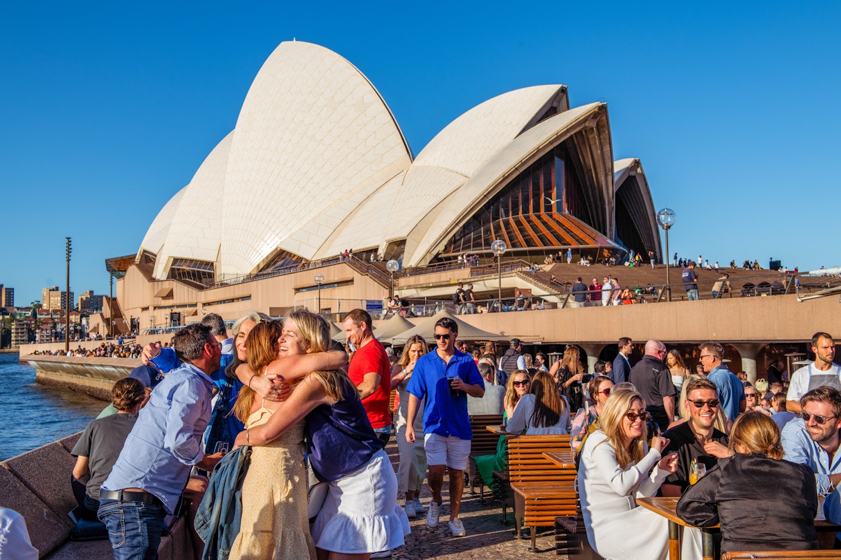 Friends hug in front of the Sydney Opera House © Isabella Moore/Lonely Planet