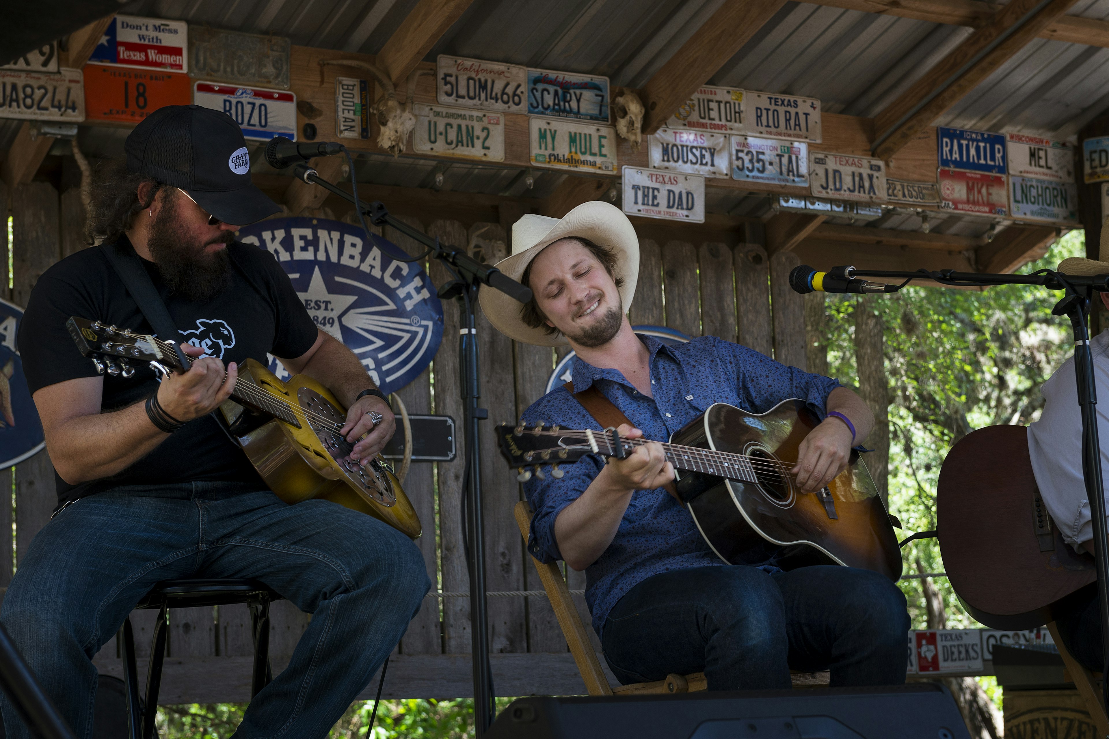 Two performers play guitars in a wooden structure