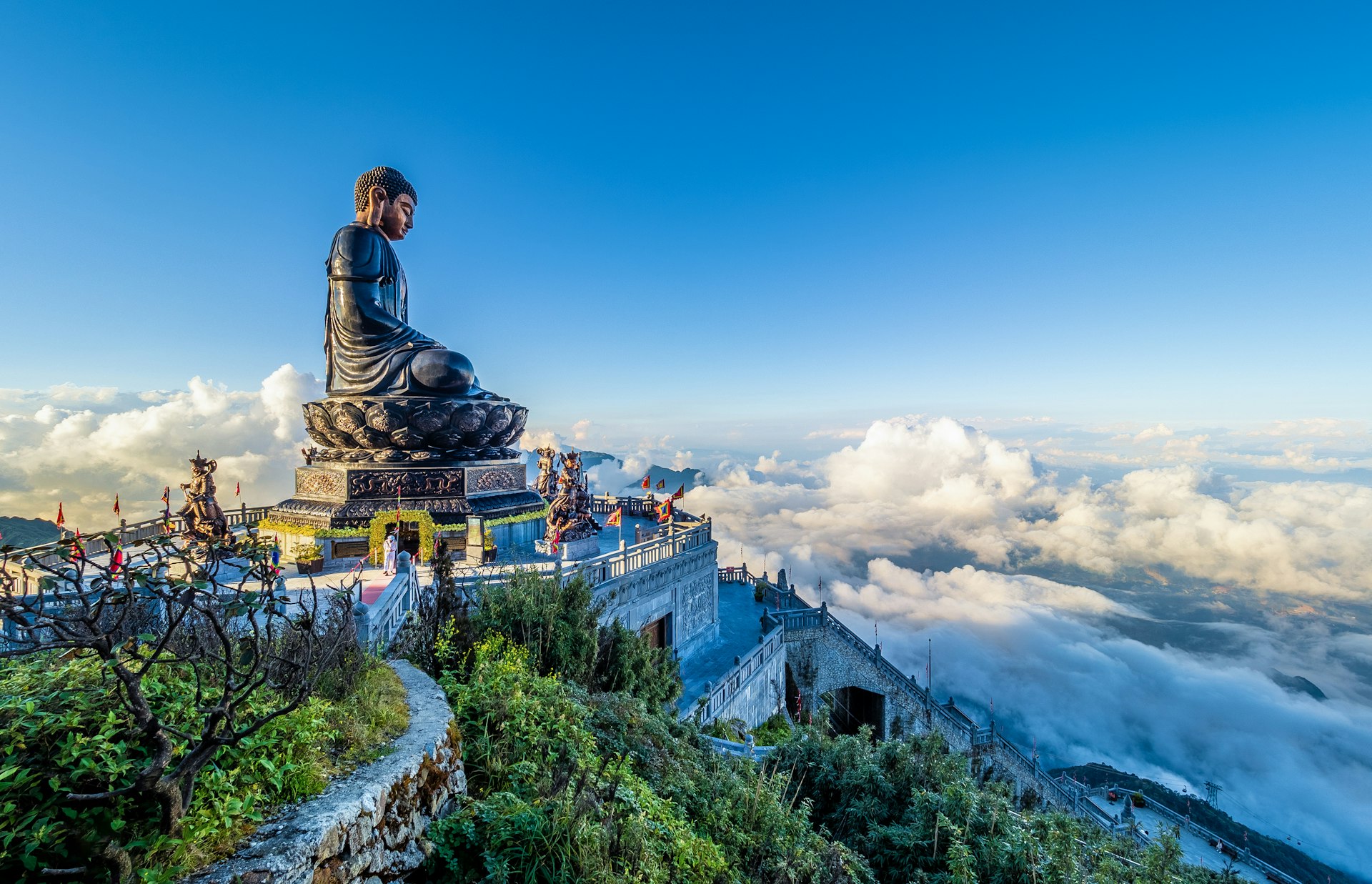 A giant Buddha statue and terrace overlooking clouds and landscapes below from the top of mount Fansipan, Đường District, Lai Chau, Vietnam
