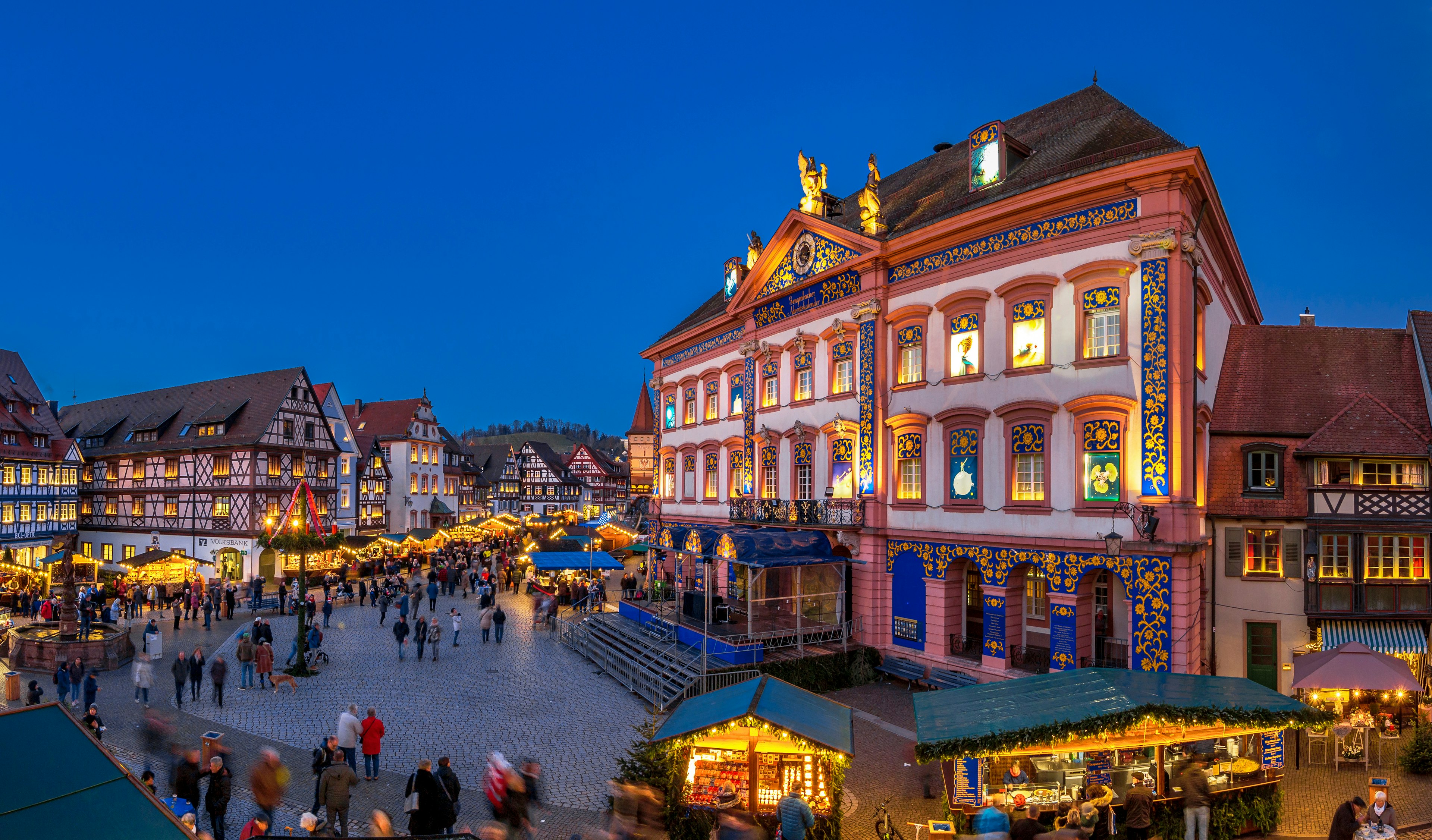 A Christmas market in front of a large building decorated as an Advent calendar