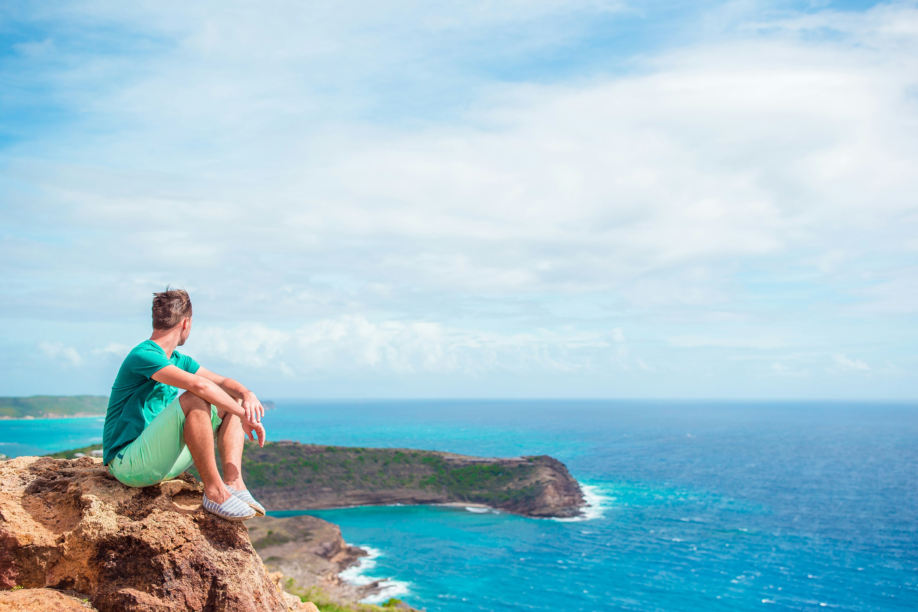 Young man enjoying breathtaking views from Shirley Heights on Antigua island