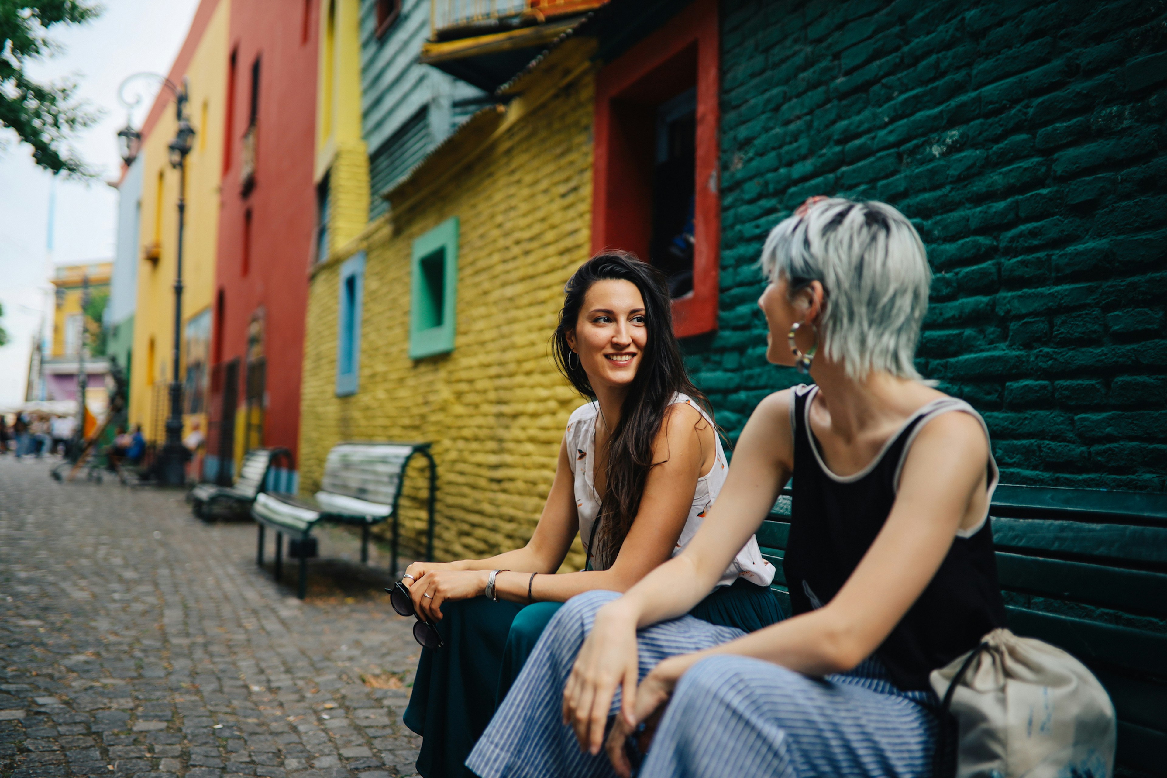 Two young women sitting in front of a colorful vintage house and talking, Buenos Aires, Argentina.
1196428949