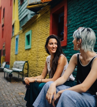 Two young women sitting in front of a colorful vintage house and talking, Buenos Aires, Argentina.
1196428949