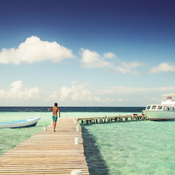 Boy in swimming trunks, walking on jetty on a hot, sunny day
825472850