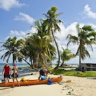 A couple gets instruction on efficient kayak packing.  Barrier reef island, Belize, Caribbean Sea.  Along the barrier reef off the coast of Belize there are many small islands like this one.
483629978
Eco Tourism, Travel, Three People, Group Of People, Beauty In Nature, Remote, Sea Kayaking, Kayak, Packing, Preparation, Advice, Getting Away From It All, Idyllic, Adventure, Tropical Climate, Vacations, Nature, Outdoors, Kayaking, Water Sport, Recreational Pursuit, People, Belize, Sand, Reef, Island, Beach, Caribbean Sea, Sea, Mode of Transport, Turquiose Water