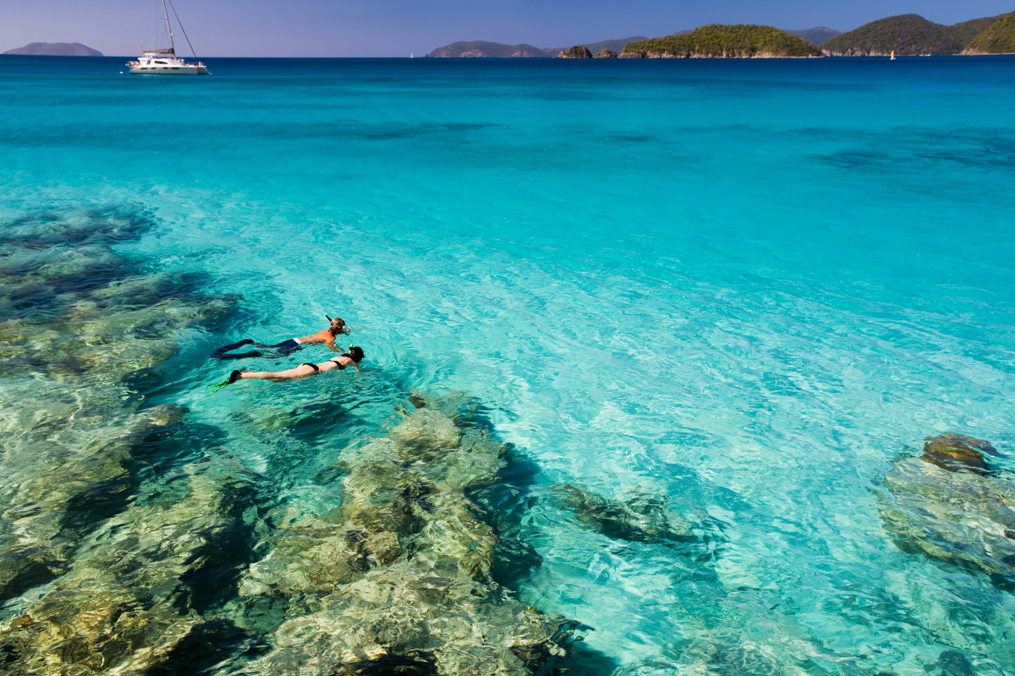 couple holding hands while snorkeling in the Caribbean crystal clear waters