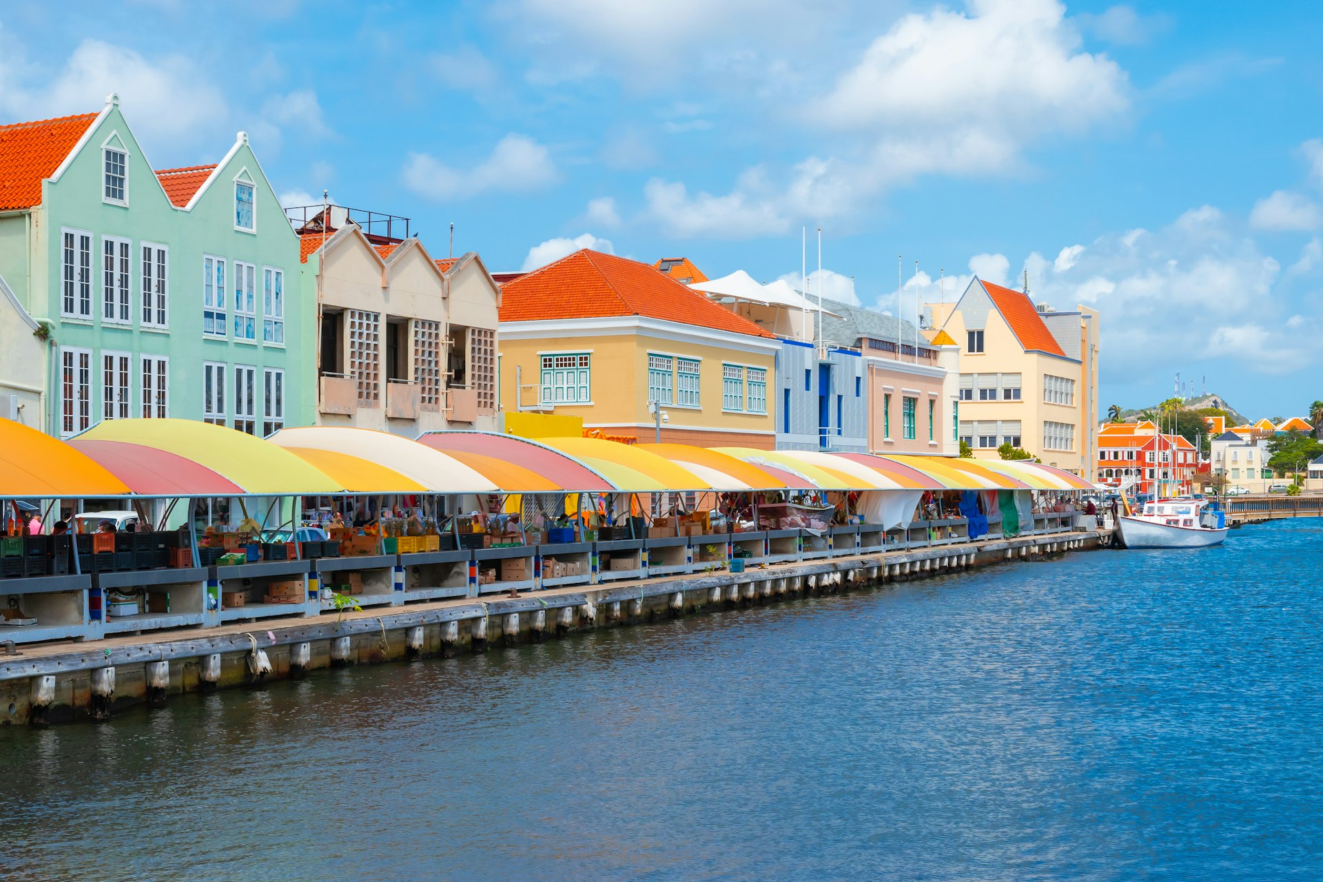 Colorful buildings with local market at the waterfront. Popular place for tourists. It used to be a floating fish market. 