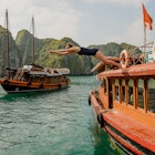 woman diving off of a boat in Halong Bay Vietnam