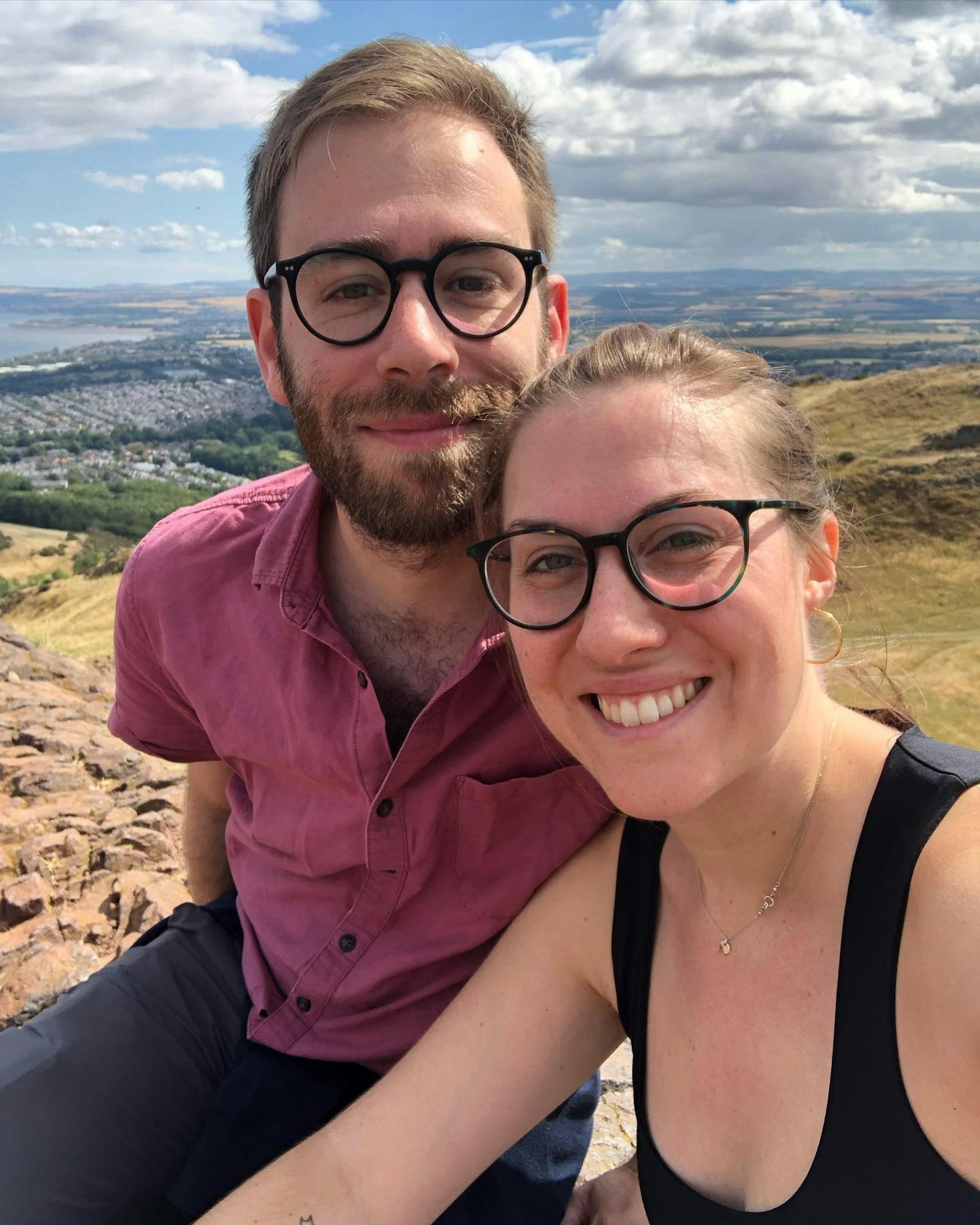 A woman and a man smile at the camera in Scotland. 