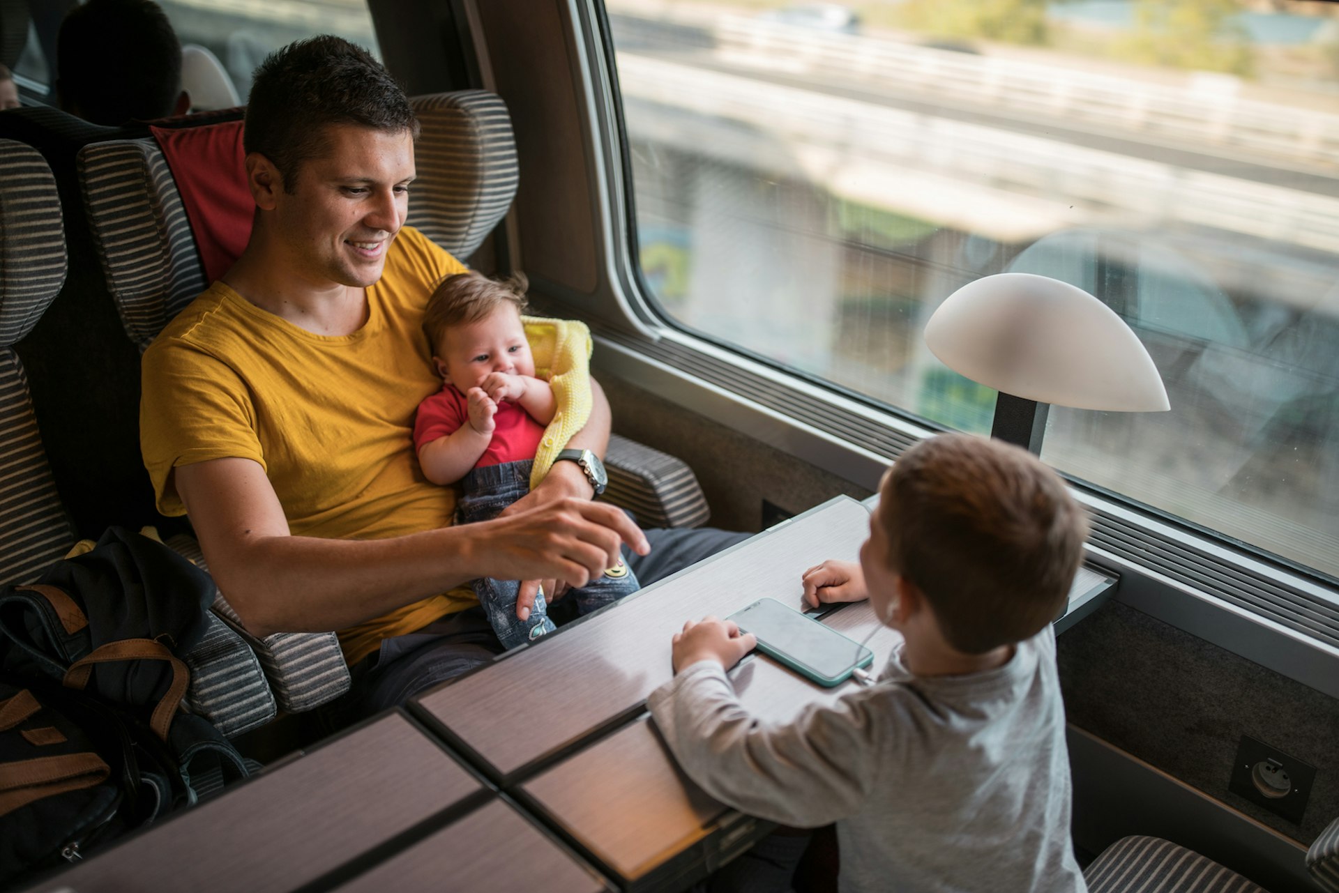 A father and two children relax aboard a high-speed TGV train, France