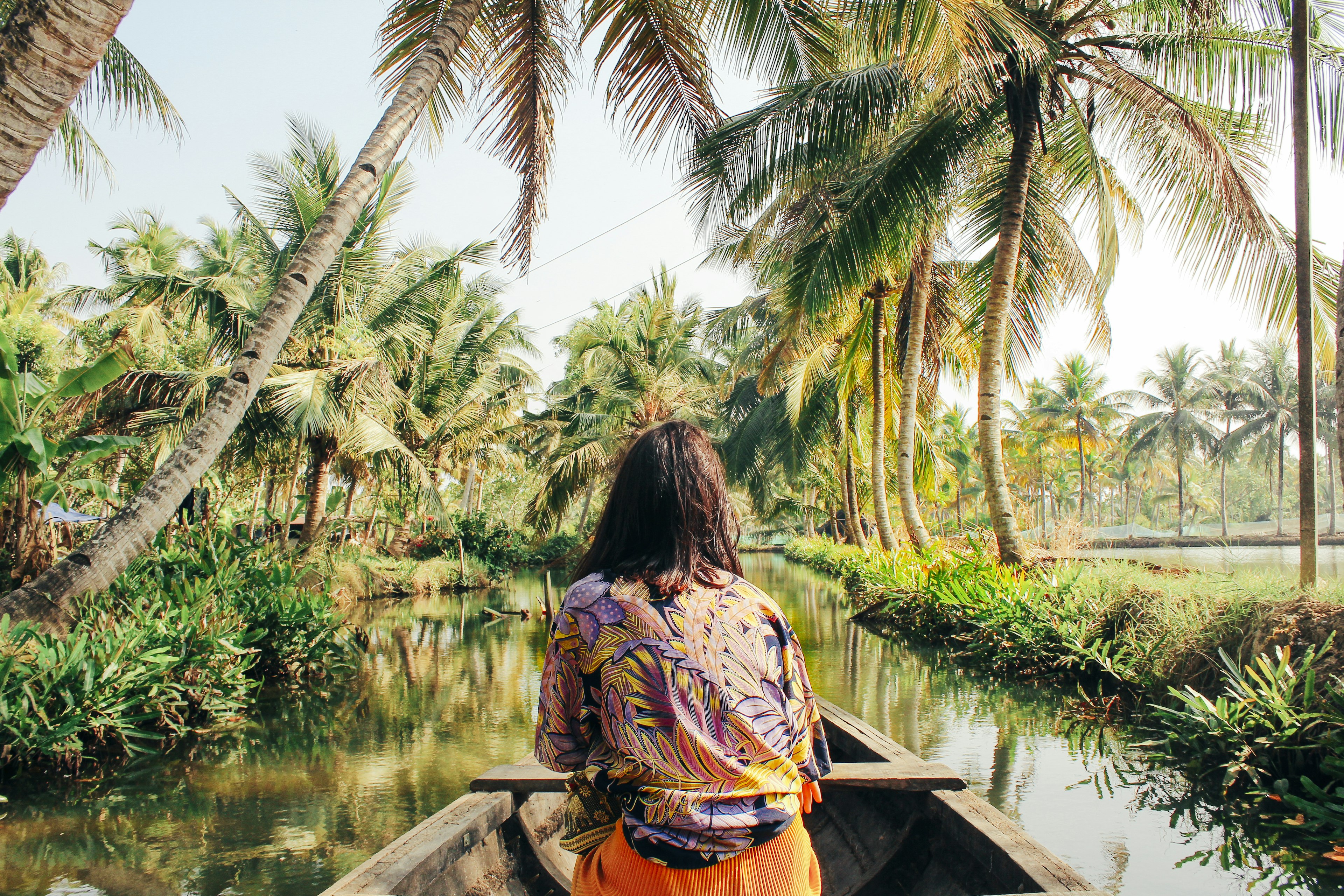 A young woman kayaks through the backwaters of Monroe Island in Kollam District, Kerala, South India