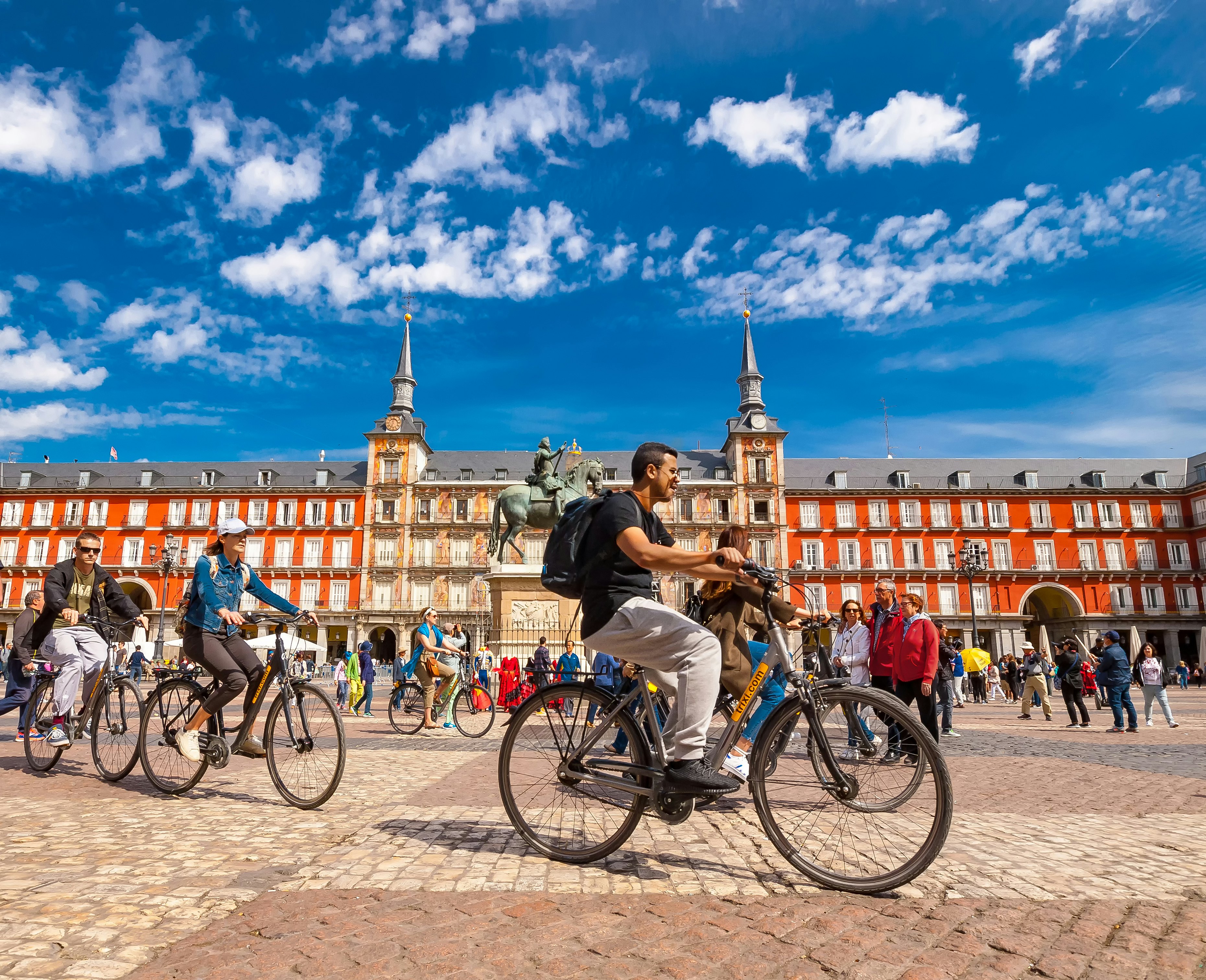 Spain, Madrid..A view of  La Plaza Mayor square in Madrid where there were a group of tourists riding bicycles. The Plaza Mayor square is one of the most famous squares in the town and located in the city center. People walk and cycle through the streets.The Plaza Mayor (Main Square) was built during Philip III's reign (1598–1621).