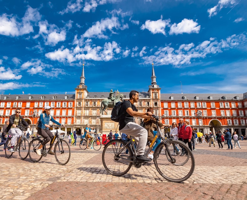 Spain, Madrid..A view of  La Plaza Mayor square in Madrid where there were a group of tourists riding bicycles. The Plaza Mayor square is one of the most famous squares in the town and located in the city center. People walk and cycle through the streets.The Plaza Mayor (Main Square) was built during Philip III's reign (1598–1621).