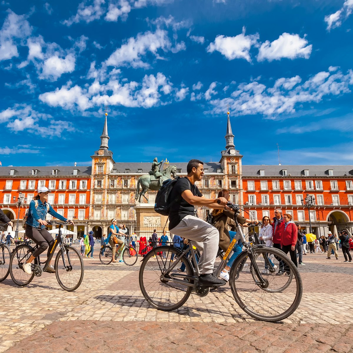 Spain, Madrid..A view of  La Plaza Mayor square in Madrid where there were a group of tourists riding bicycles. The Plaza Mayor square is one of the most famous squares in the town and located in the city center. People walk and cycle through the streets.The Plaza Mayor (Main Square) was built during Philip III's reign (1598–1621).