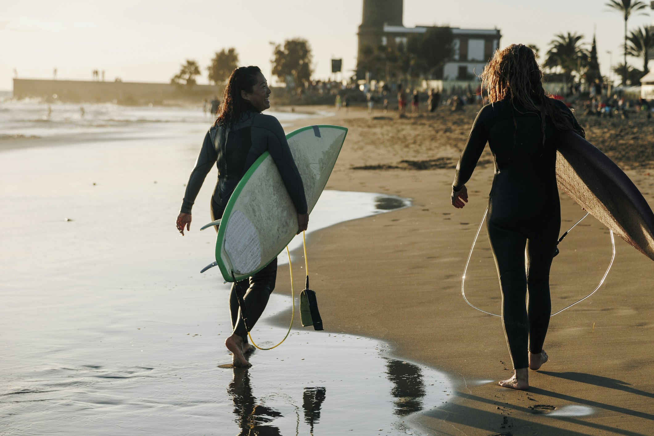 Female surfers with surfboards walking together on beach, Gran Canaria, Canary Islands