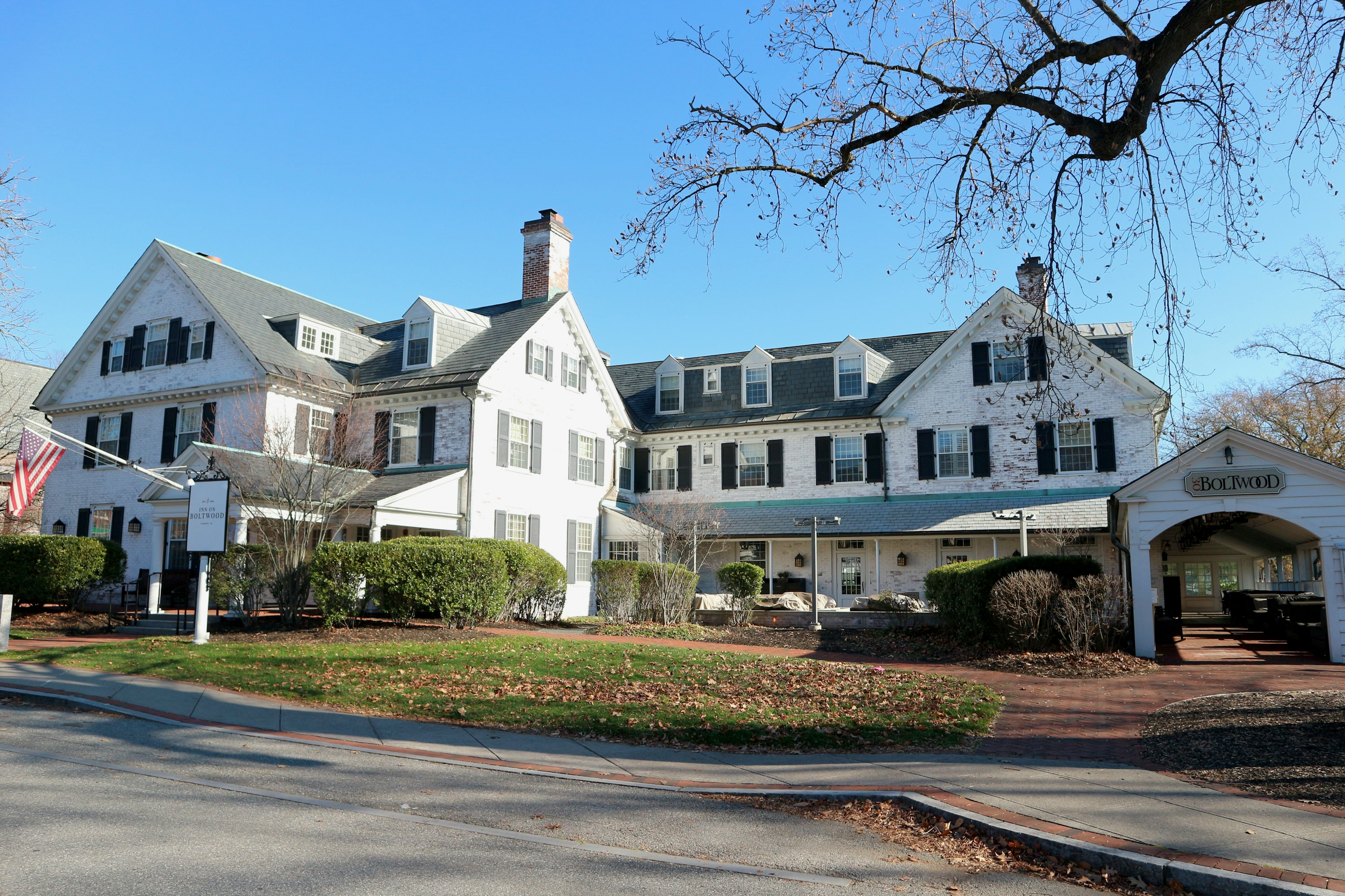 The exterior of a grey and white Victorian inn.