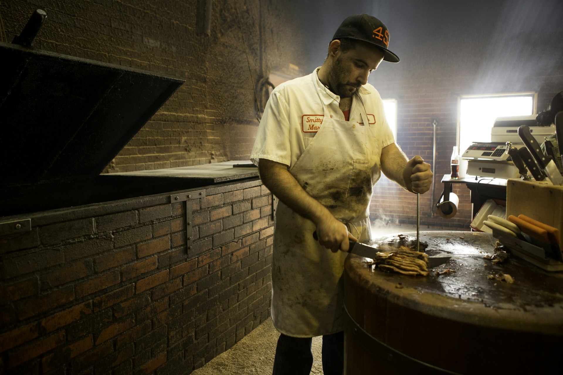 A worker slices barbecue for a customer at Smitty's Market in Lockhart, Texas