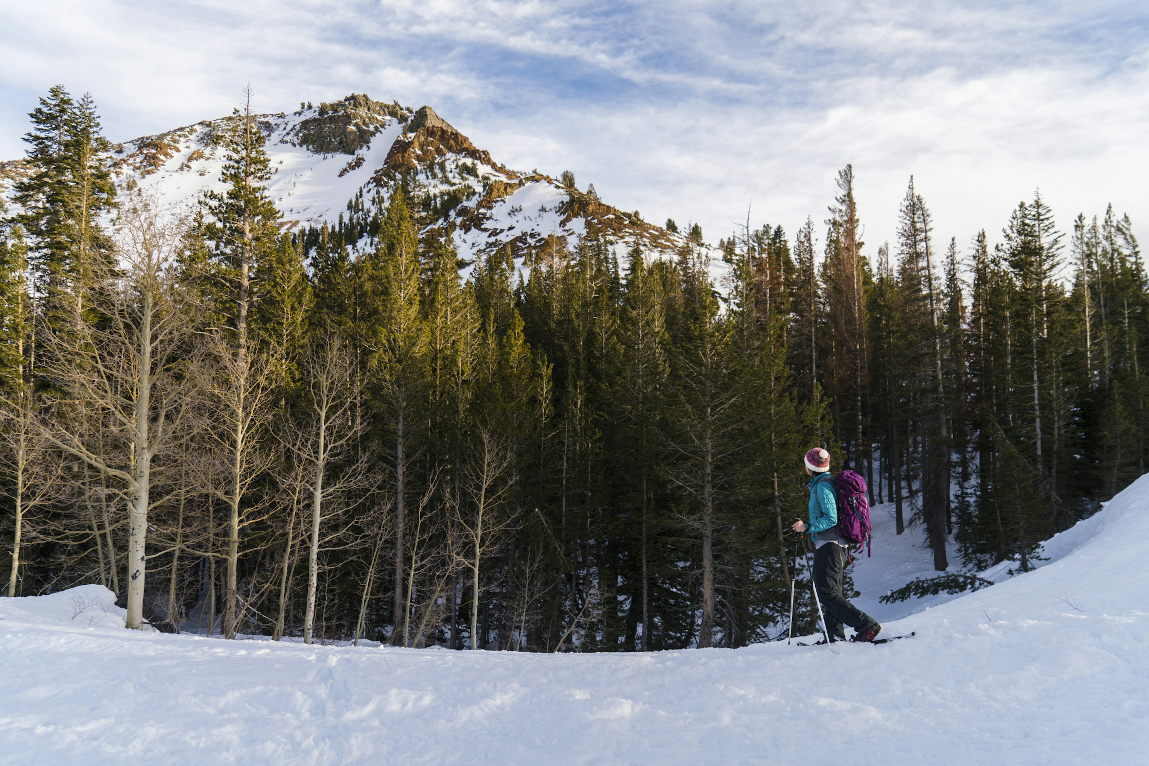 Woman with ski poles walking on snowy field