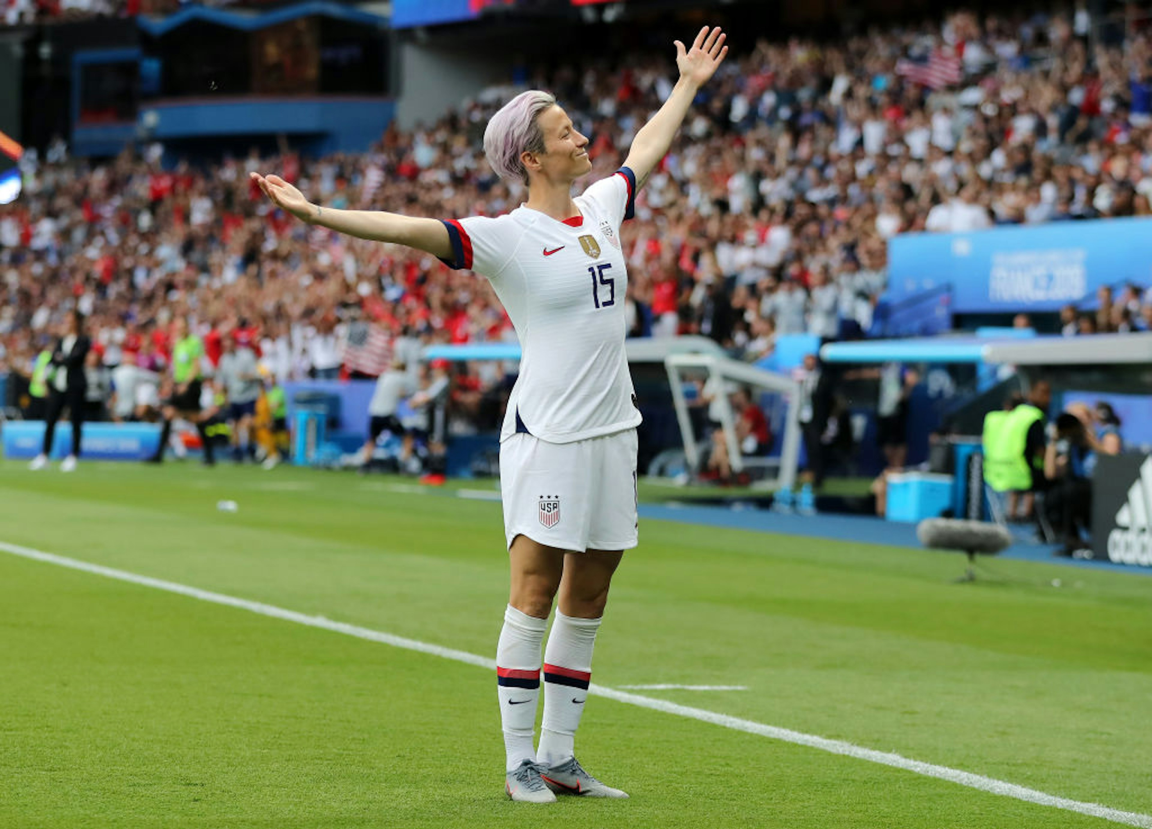 US soccer team co-captain Megan Rapinoe stands on the pitch with her arms outstretched during the France v USA Quarter Final game in the 2019 FIFA Women's World Cup in France