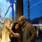Couple window shopping in city at night, New York, USA