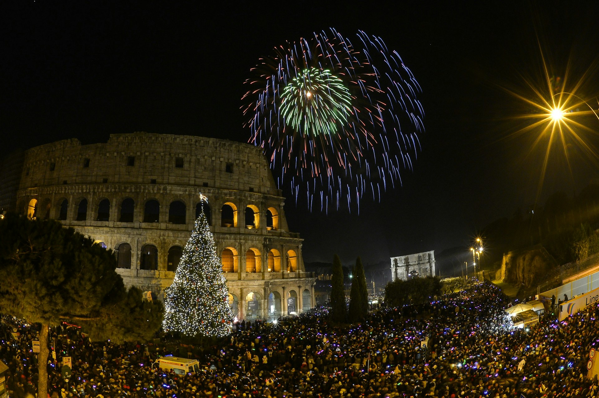 People cheer in front of Rome's ancient Colosseum as fireworks explode to celebrate the new year.