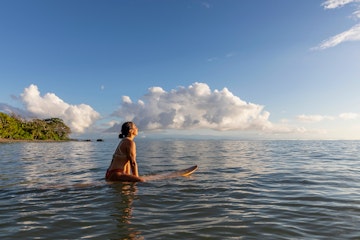 Stock Photo of Beautiful Hispanic female surfer in Costa Rica at sunrise