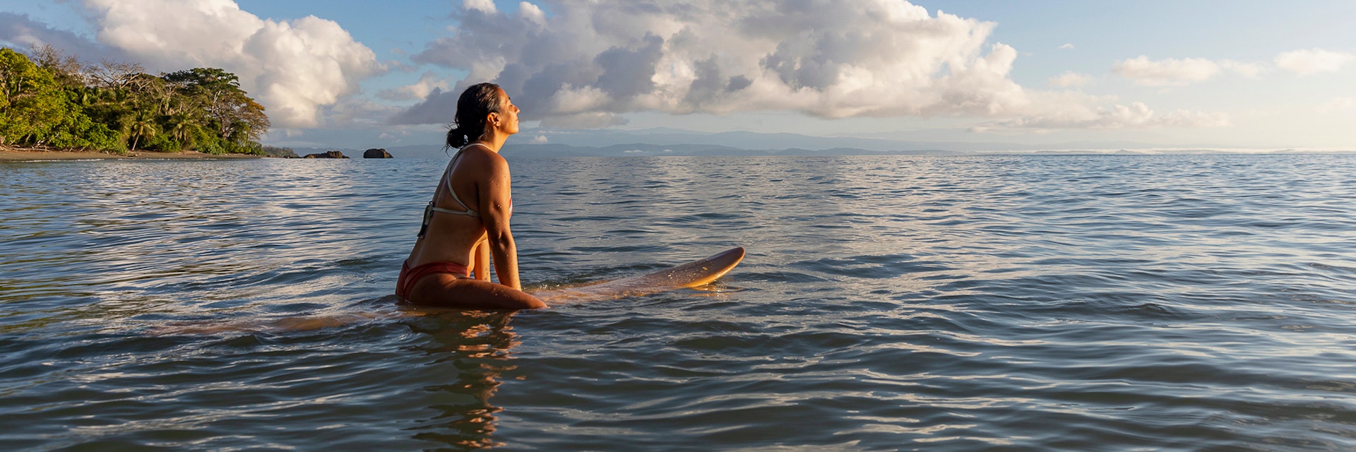Stock Photo of Beautiful Hispanic female surfer in Costa Rica at sunrise