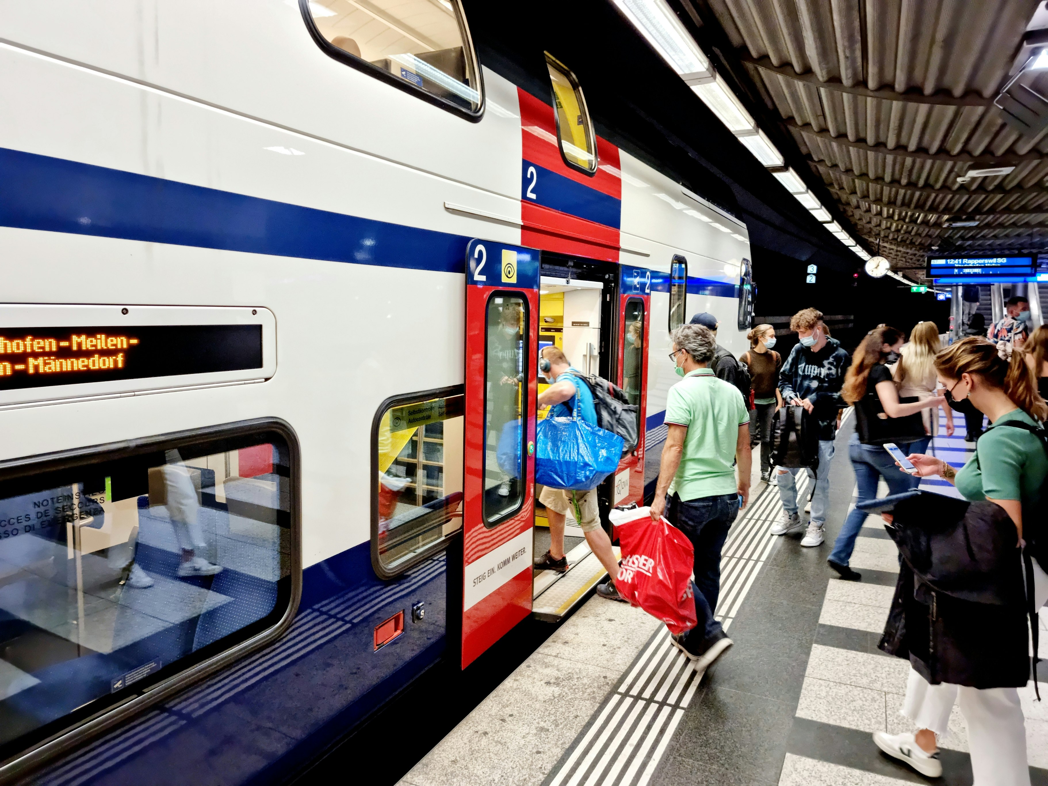 Zurich Main Railway Station with underground level. The image shows a S-Bahn service with several passengers get in to the train.