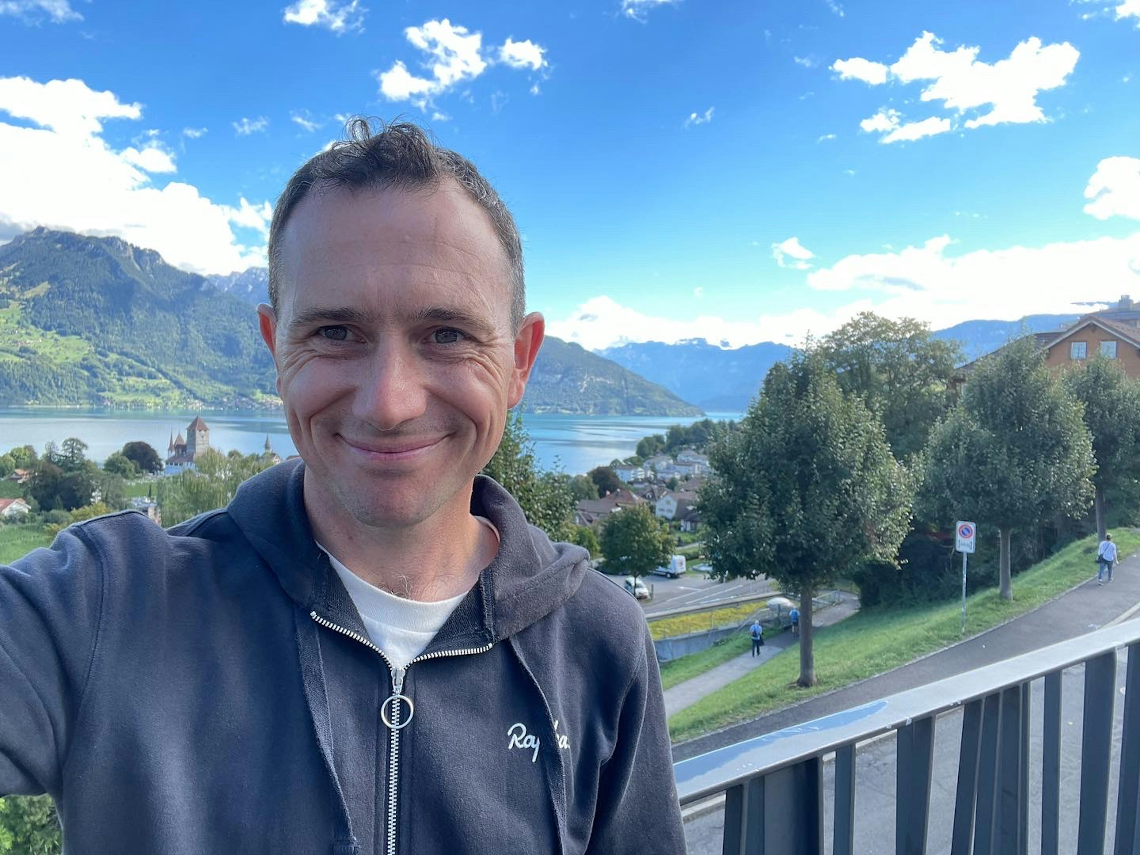 A man smiles for the camera in the Swiss mountains.