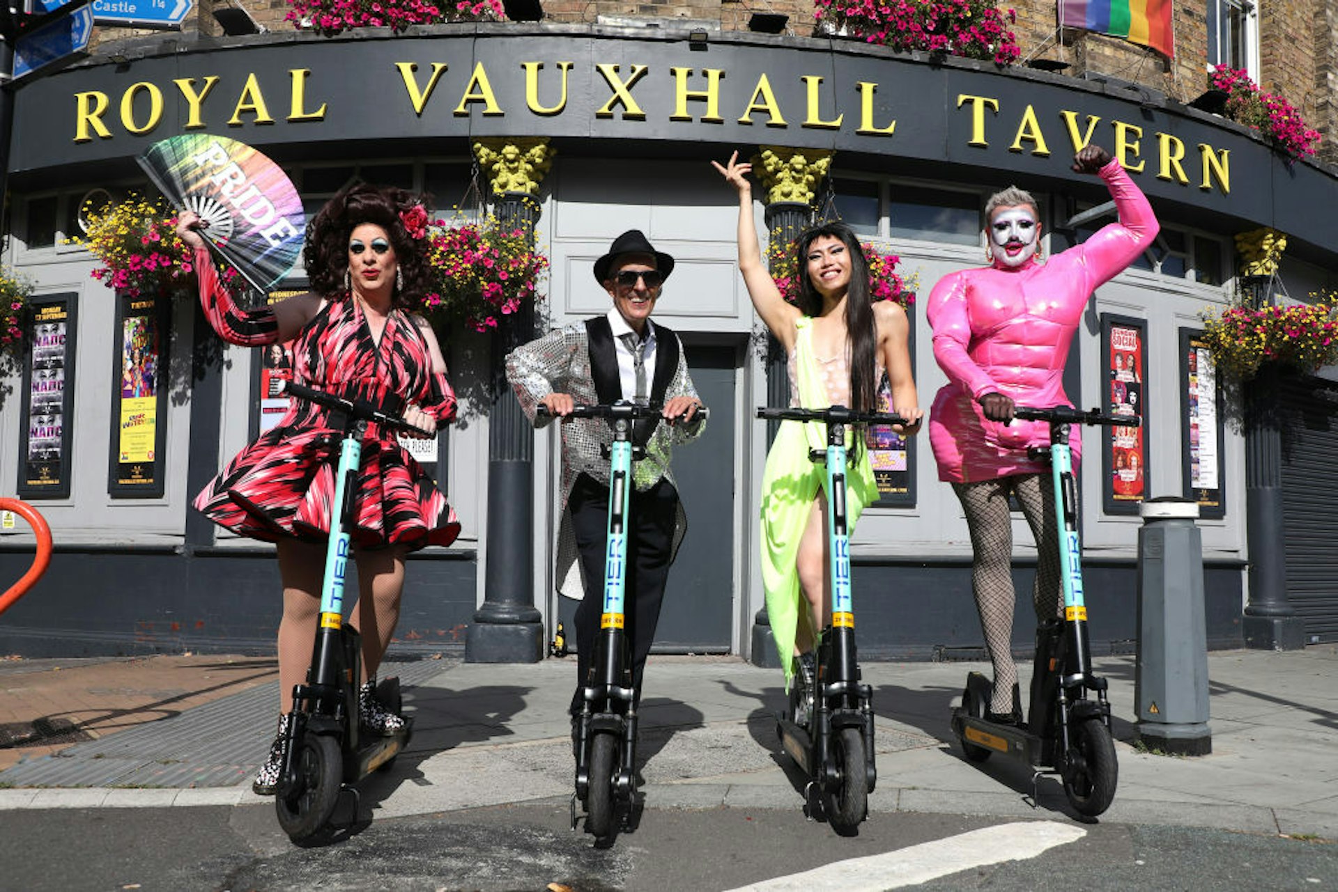 Four drag queens stand on scooters outside the Royal Vauxhall Tavern in London