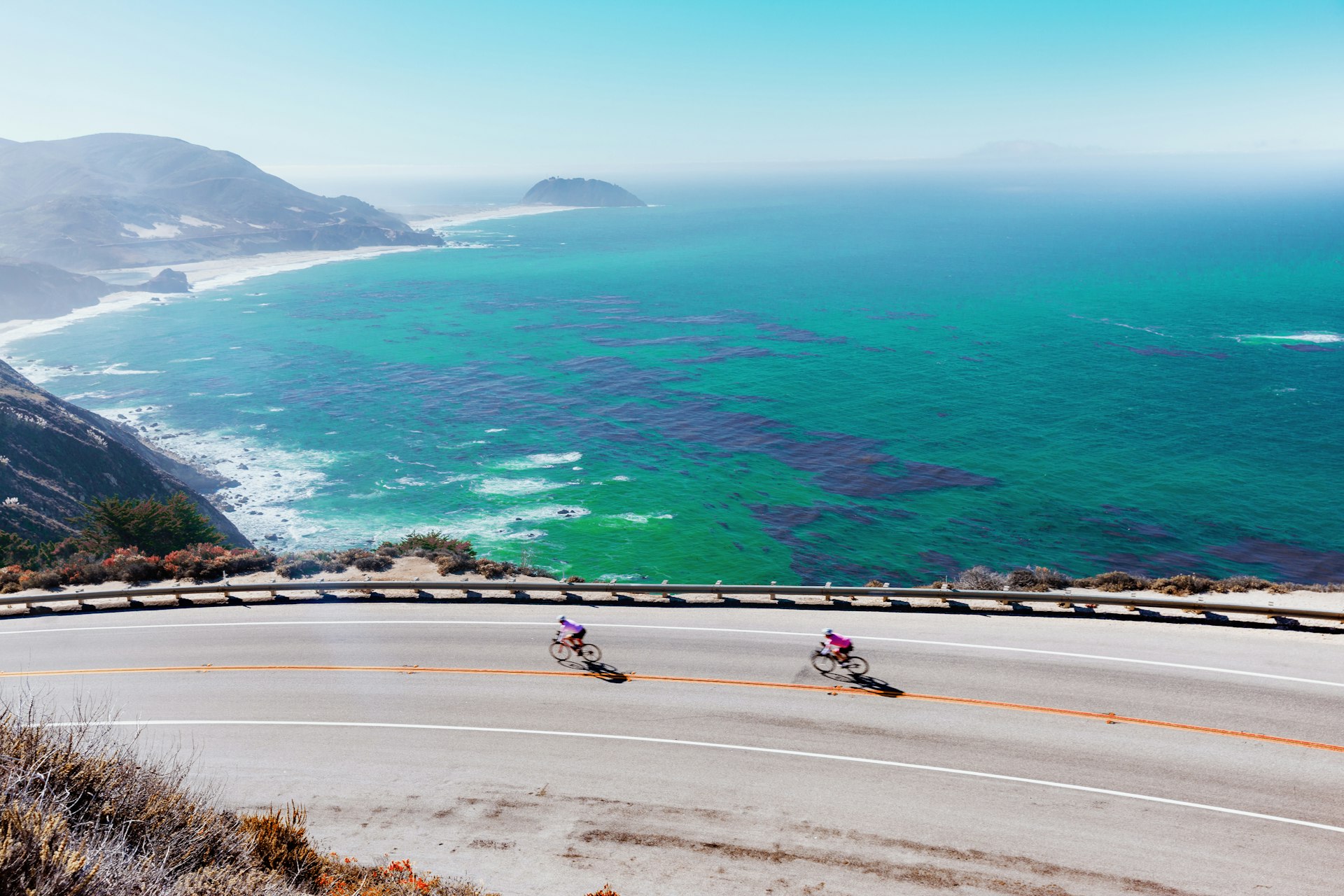 Two cyclists on Highway 1 on the Big Sur Pacific Coast of California.