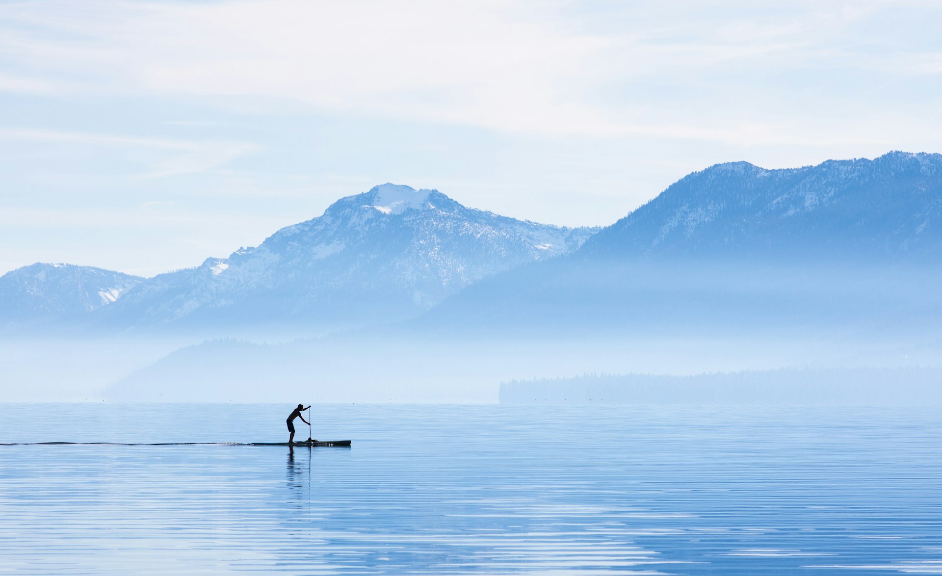 A paddleboarder goes for a morning cruise around the shore of Lake Tahoe