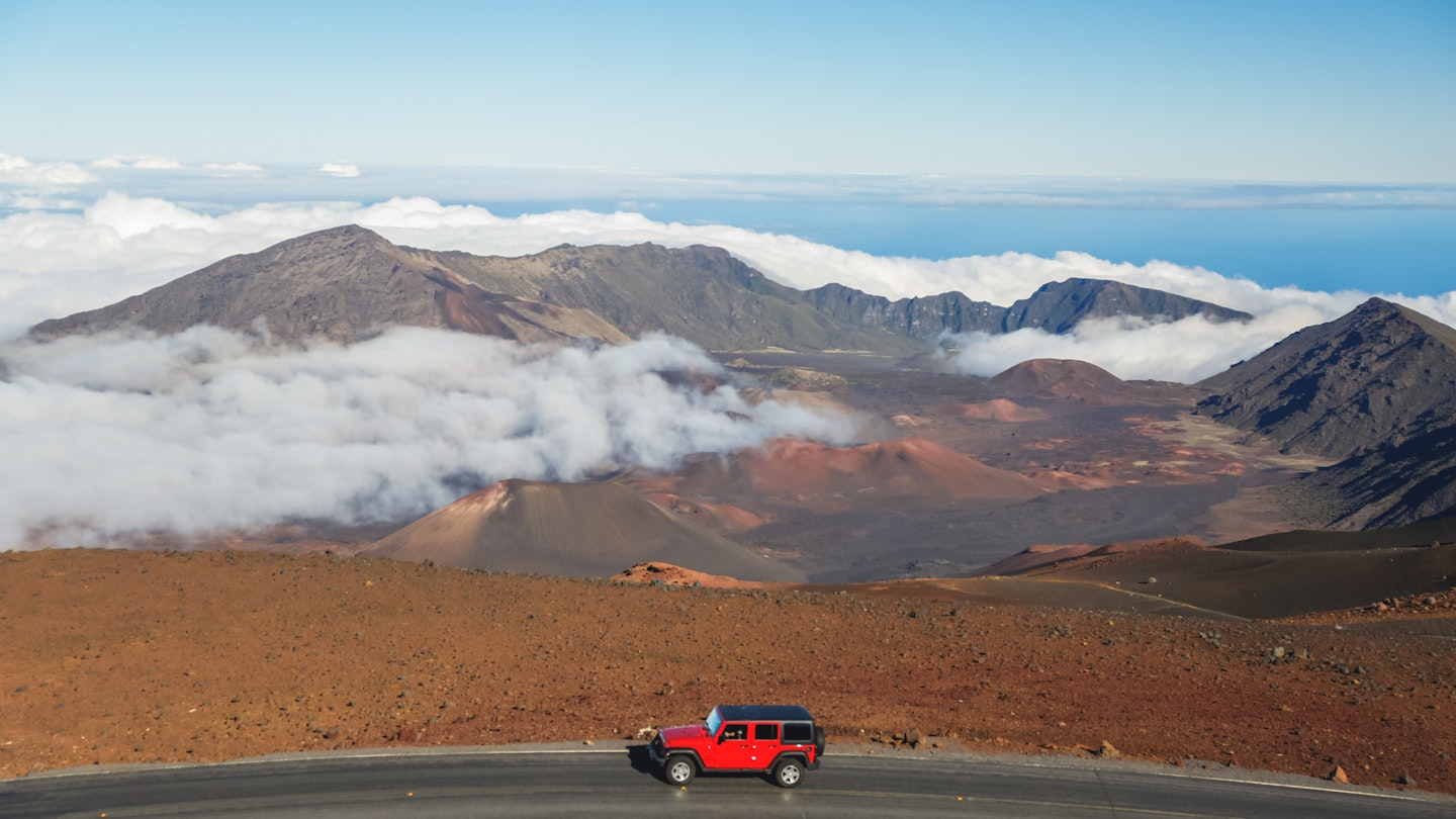 The volcanic landscape of Haleakala National Park with a red car passing, Maui, Hawaii, USA.
636950846