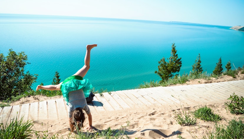 705209981
One Person, Lifestyles, Childhood, Outdoors, Turquoise Colored, Beauty In Nature, Boardwalk, Scenics, Shore, Day, Sleeping Bear Dunes National Lakeshore, Plant, Girls, Travel, Idyllic, Real People, Travel Destinations, Freedom, Carefree, Casual Clothing, Enjoyment, Handstand, Tourism, Leisure Activity, Sunlight, Cartwheel, Sky, Non-Urban Scene, Rear View, Practicing, Lake, Nature, Lake Michigan, Water, 4-5 Years, Horizontal Image
