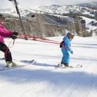 Mother teaching son (4-5) how to ski