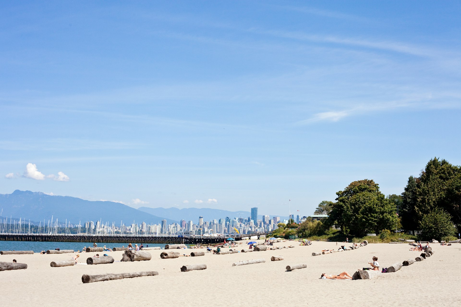  A summer day on Jericho Beach in Kitsilano. People are spread out on the beach with the city of Vancouver in the background